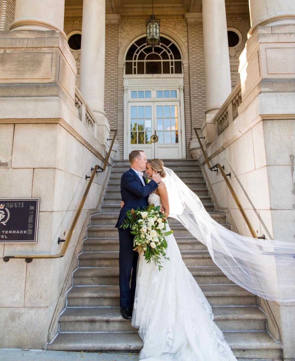Bride and groom on grand wedding steps